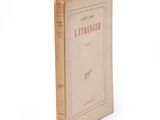 an old book sitting on top of a table next to a white wall