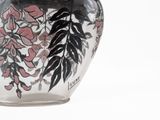 a glass vase with a black and pink design on it