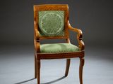 an old chair with a green upholstered seat in a dark room