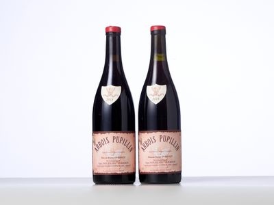 two bottles of wine sitting on top of a table next to each other