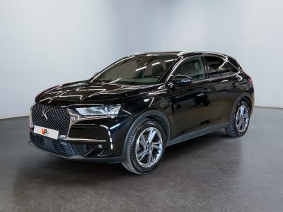 Un SUV noir est garé dans une pièce aux murs blancs.