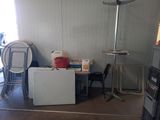 une photo d'une pièce avec un réfrigérateur, une chaise et une table