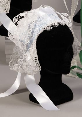 a black mannequin head with a white lace veil on it