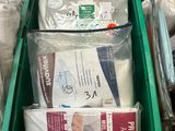 a green box filled with a lot of diapers on top of a bed