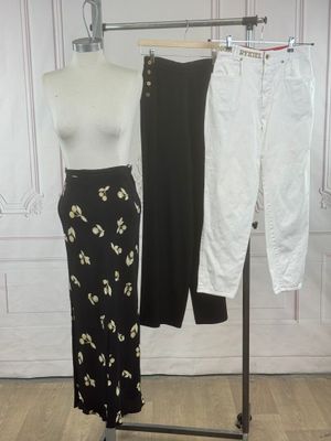 a mannequin and pants on a rack in front of a wall