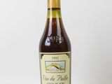 une bouteille de vin posée sur une table blanche