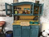 a blue cabinet with a yellow top in the corner of a room