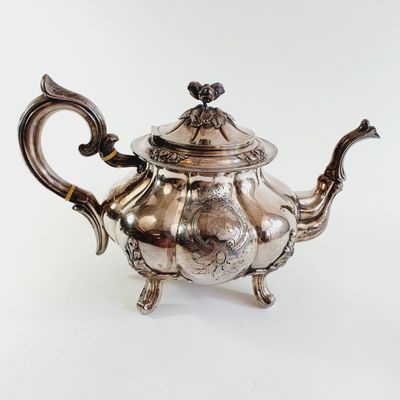 an antique silver teapot with a handle and handle on a white background