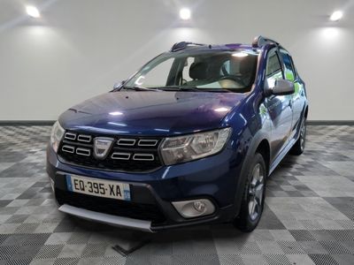 une photo d'une dacia bleue garée sur un sol en damier