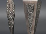 pair of silver spoons on a black surface with a gray background