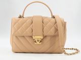 un sac à main beige muni d'une bandoulière en chaîne et d'un fermoir doré