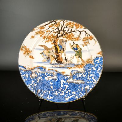 a blue and white plate with a painting on it