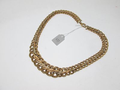 a close up of a gold chain necklace on a white surface
