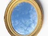 un miroir rond dans lequel se reflète un ciel bleu