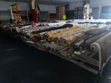 many rolls of fabric on a conveyor belt in a factory