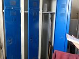 two blue lockers in a room with a person standing next to them