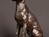 bronze statue of a dog sitting on a wooden table