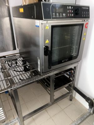 un four argenté posé sur une grille métallique dans une cuisine