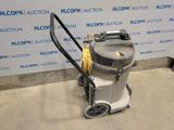 the vacuum is sitting on the floor in front of the wall