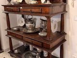 a wooden shelf with silver dishes on top of it