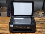 a printer sitting on top of a wooden table next to boxes