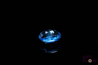 gros plan d'un diamant bleu sur une surface noire