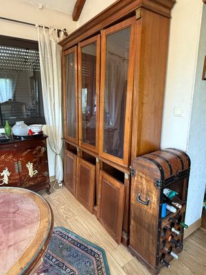 a large wooden cabinet with a wine rack in the corner
