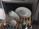 a dishwasher filled with dishes and utensils in a kitchen