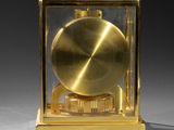 a golden clock that is sitting in a glass case