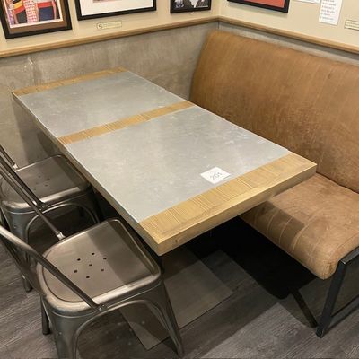 une table et des chaises dans une alcôve, avec des tableaux accrochés au mur