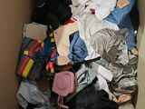 a cardboard box filled with clothes and bags