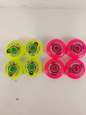 quatre roues de skateboard sont alignées sur une surface blanche