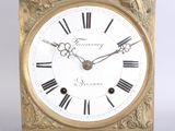 a gold clock with roman numerals on the face