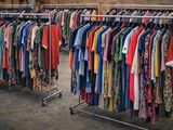 a lot of clothes hanging on a rack in a room