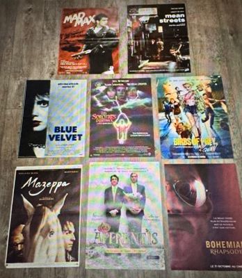 diverses affiches de cinéma posées sur un parquet dans une pièce