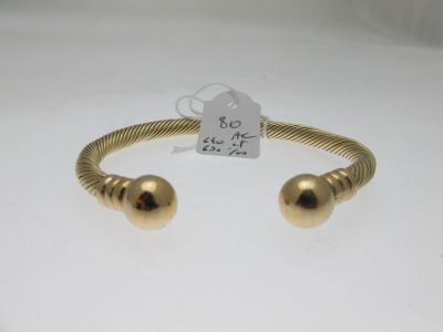 un gros plan d'un bracelet en or orné de deux boules