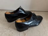 pair of black leather shoes sitting on top of a marble floor