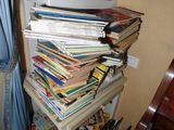 une pile de livres posée sur une étagère dans un coin de la pièce