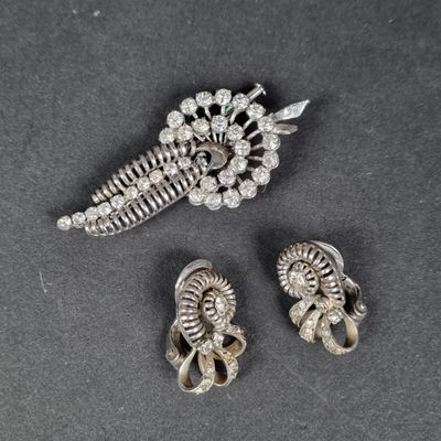 three pieces of silver jewelry on a black surface