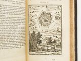 an open book with a drawing of a town in the middle of it