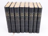 six black books lined up on top of each other on a white surface
