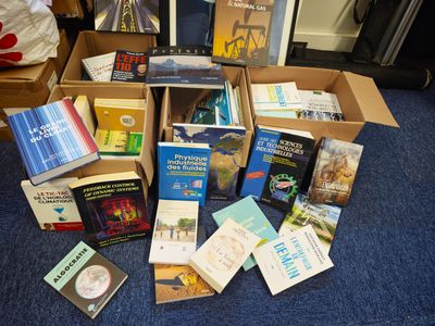 de nombreux livres qui sont rangés dans une boîte posée par terre