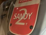 someone is holding a red and white sign that says sandy 2