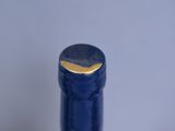 close up of a blue wine bottle with a gold cap