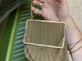 someone is holding a small purse with a chain around it
