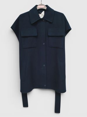 a black shirt hanging on a hanger on a white wall