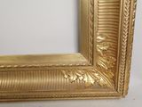 an image of a picture of a gold frame on a white wall