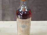 an old bottle of whiskey sitting on top of a wooden table