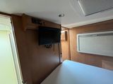a television mounted on the wall above a bed in a camper
