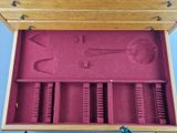 a wooden box with tools inside of it on a blue surface
